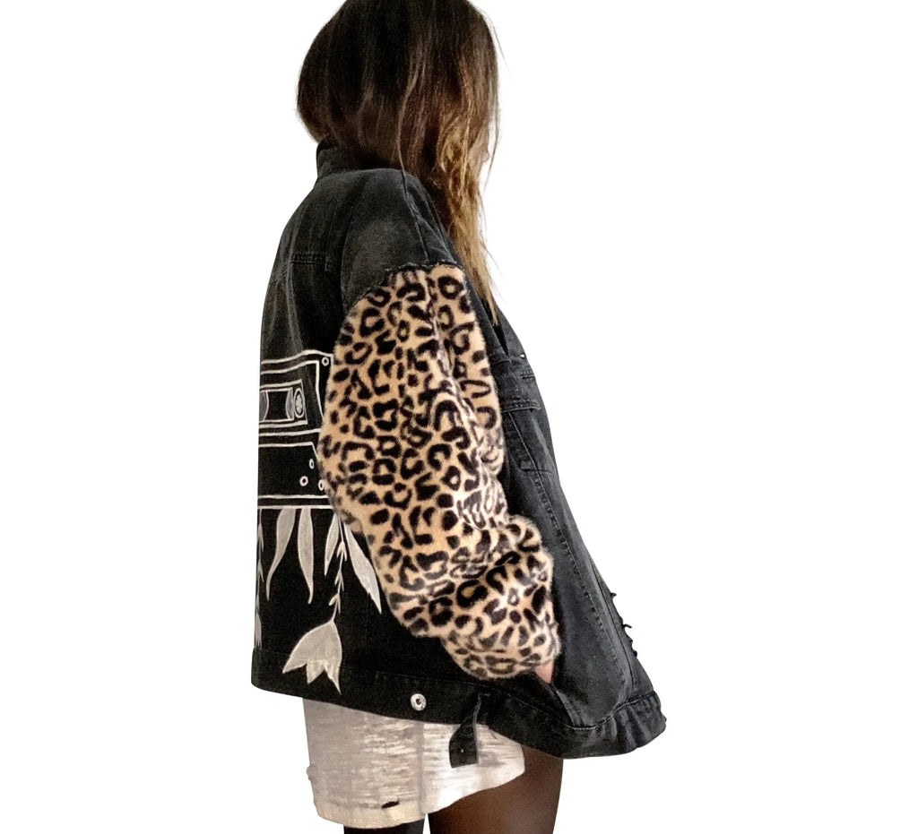 Black denim jacket with super comfortable leopard pattern sleeves. Large white cassette tape painted on back, with white flowers and leaves sprouting out. Signed @wrenandglory.