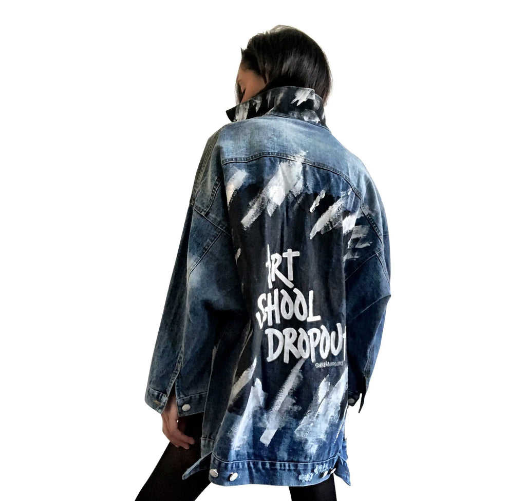 Dark blue denim jacket with long back. White and black pattern painted on back, with ART SCHOOL DROPOUT painted over it in white. Collar and front pockets painted with black and white pattern. Signed @wrenandglory.