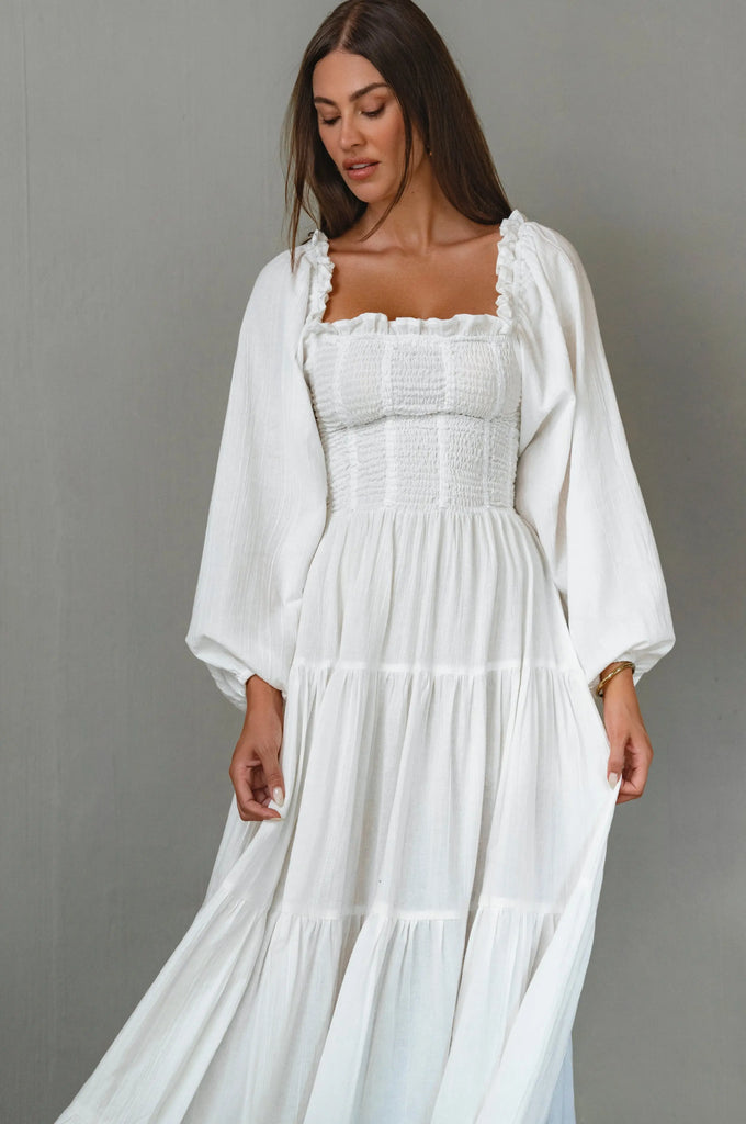 Woman wearing a white dress with a plain background cottage core style