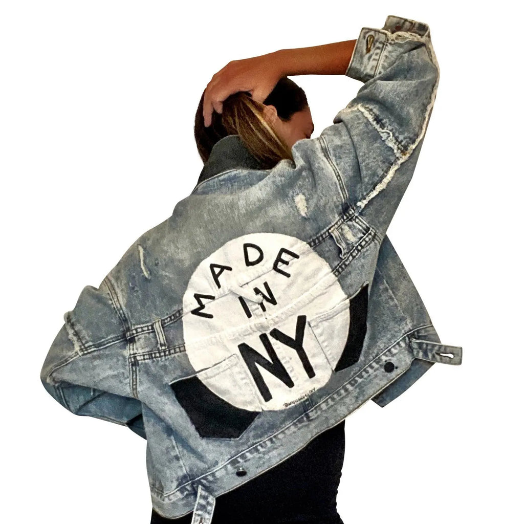 Lighter blue denim wash. White circle, painted MADE IN NYC inside in black.  Pockets and hems painted black Signed @wrenandglory.
