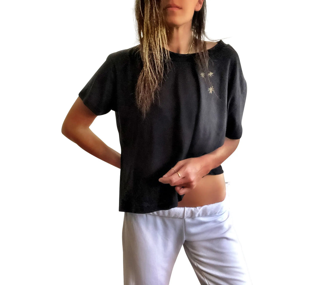 The perfect cropped black T shirt. Assorted color metallics and white splatter and stripes painted on back, with small stars painted on front, upper left side in gold. Signed @wrenandglory.