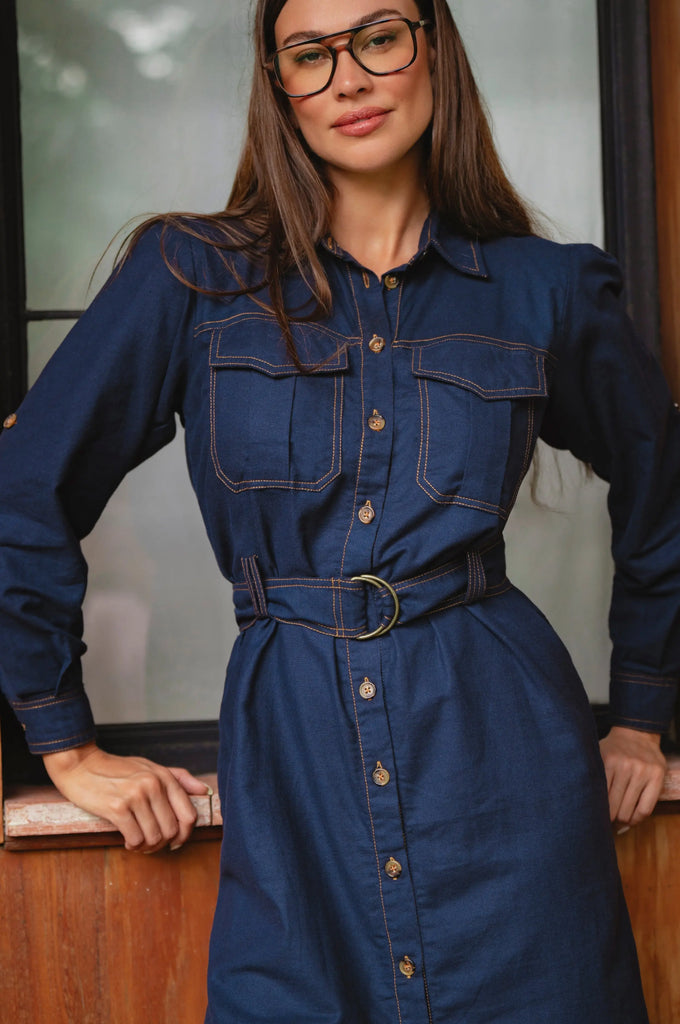Woman wearing a blue denim dress with a belt, standing indoors - cottage core style