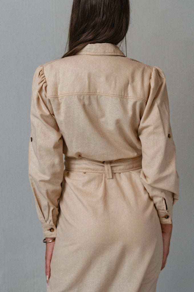 Woman wearing a beige dress with buttons 