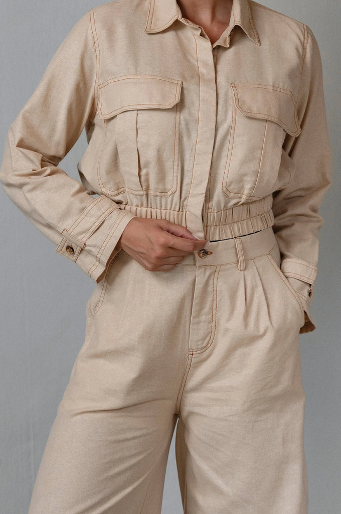 Beige linen set worn by a person on a gray background