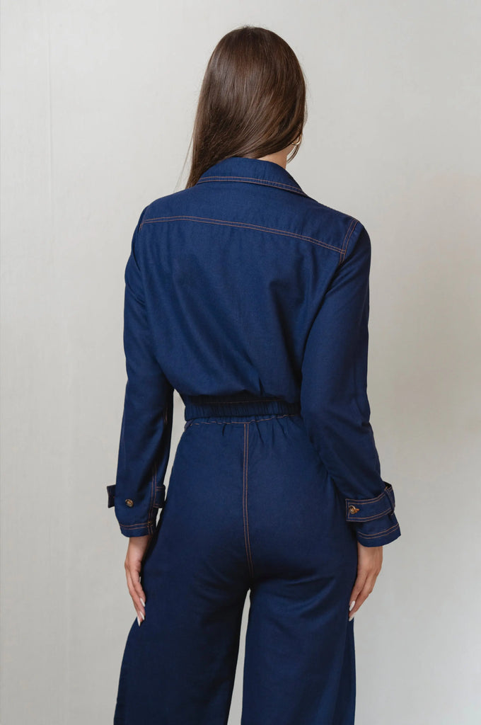 Person wearing a blue linen set with jacket against a plain background