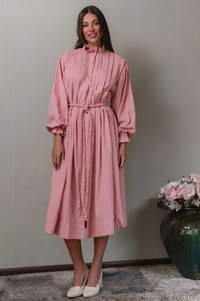 Woman wearing a pink linen dress with long sleeves